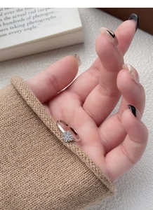 Close-up of S925 silver snowflake ring with zircons worn on hand against a warm sweater