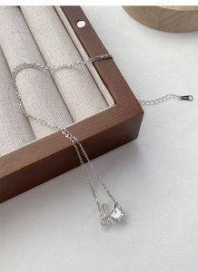 Detailed close-up of S925 sterling silver bow heart necklace with diamond engraving