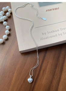 Macro detail of S925 sterling silver ball chain necklace with polished heart pendant