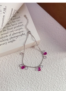 Détail du poinçon S925 argent et du zircon rose en goutte sur un bracelet chaîne à perles