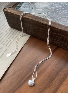 Detail view of S925 sterling silver heart necklace with bead chain on jewelry box