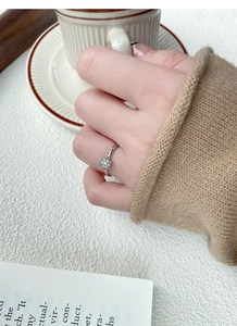 Close-up of S925 sterling silver daisy ring with micro-pave zircons on a model finger