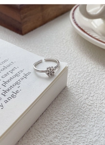 Macro shot of S925 sterling silver snowflake ring with zircons on white book edge
