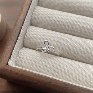 Elegant S925 sterling silver bow ring with bead detail displayed in a jewelry box
