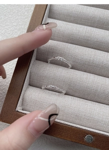 Close-up of S925 silver bow rings with beaded texture in a premium jewelry box