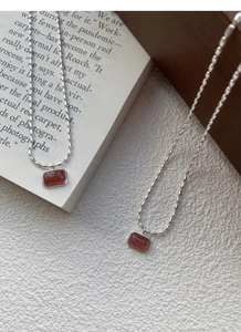 Close-up of S925 silver necklace featuring a rectangular strawberry quartz stone pendant