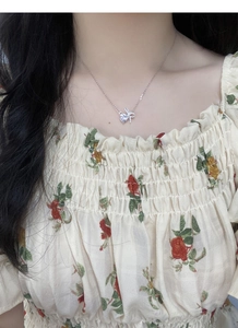 Close-up of S925 silver heart bow necklace with micro-pave crystals on female model