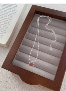 Detail of S925 sterling silver chain with strawberry quartz pendant in a wooden box