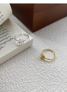 Detailed view of hollow floral pattern adjustable rings in gold and silver finish