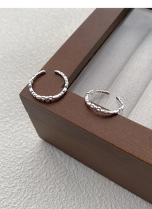 Macro shot of polished S925 sterling silver bow knot ring with adjustable open band detail