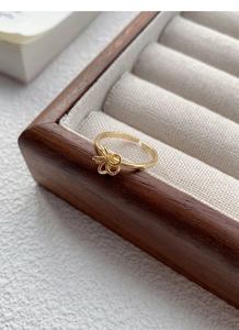Detail of golden hollow flower ring on a luxury jewelry display tray with macro focus