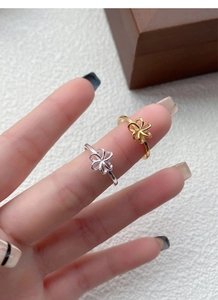 Close-up of S925 sterling silver hollow flower rings in gold and silver finishes