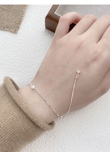 Détail du bracelet chaîne en argent S925 avec zircon rond et breloques étoile au poignet