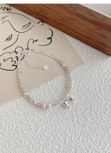 Detail of S925 silver bracelet featuring pink beads, pearls and bow-knot charm