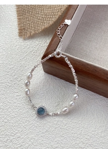 Détail du bracelet en argent S925 avec aigue-marine bleue, perles et breloque en cœur