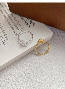 Detail of silver and gold knot rings on a vintage book, focusing on the twisted texture