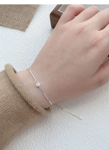 Détail macro du bracelet en argent S925 à maille vénitienne avec un zircon rond brillant