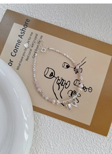 Detail of S925 silver bracelet with pink beads, freshwater pearls and bow pendant