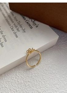 Detailed side view of a gold hollow bow ring with a polished open band design