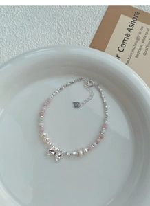 Detailed macro view of S925 sterling silver stamp and pink bead freshwater pearl bracelet