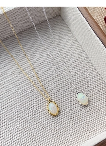 Detail view of gold and silver 925 sterling silver necklaces with iridescent opal pendants