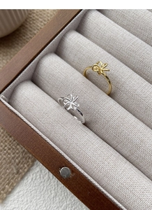 Detail view of S925 sterling silver hollow flower rings in gold and silver finishes