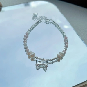 S925 silver bracelet featuring natural freshwater pearls and a pink bow pendant