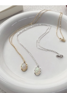 Detail view of gold and silver S925 sterling silver necklaces with oval opal pendants