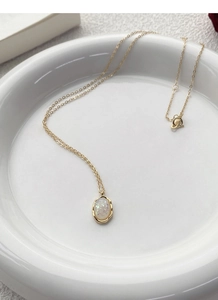 Detailed view of S925 sterling silver mark on a gold plated chain with opal pendant