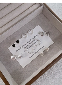 Macro view of S925 sterling silver earring set with heart and star motifs in a jewelry box
