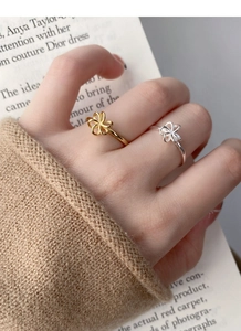 Detail of elegant hollow flower rings in gold and silver finish worn on fingers