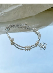 Detail eines Armbands aus 925er Sterlingsilber mit Süßwasserperlen und Blumenanhänger