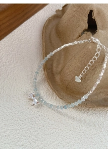 Detailed view of S925 silver bracelet with blue aquamarine beads and bow pendant