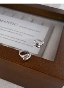 Macro shot of S925 sterling silver hoop earrings with fluid water drop design on card