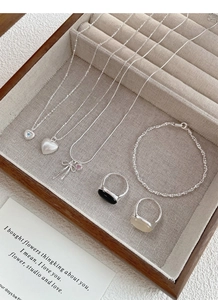 Dettaglio di un set di gioielli in argento S925 con collane a cuore e anelli in espositore