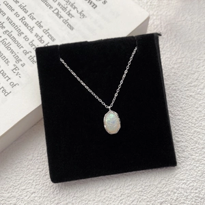 925 sterling silver opal necklace with an oval gemstone and wavy metal edge on a black base