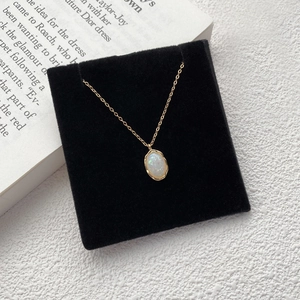 Elegant 925 sterling silver gold necklace with oval iridescent opal pendant on black velvet
