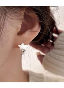 Close-up of minimalist S925 sterling silver star stud earring on model's ear