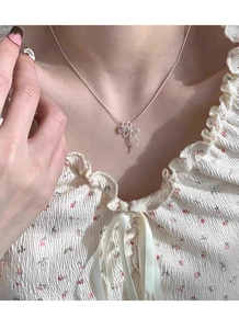 Dettaglio della collana in argento S925 con pendente a cuore rosa e fiocco sul collo