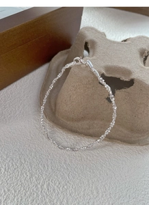 Vista dettagliata di un bracciale a catena ritorta in argento con chiusura a moschettone