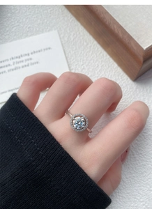 Dettaglio ravvicinato dell'anello in argento S925 con moissanite e halo sulla mano