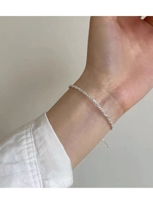 Dettaglio del bracciale minimalista in argento con perline sfaccettate sul polso
