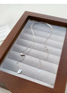 Macro detail of S925 sterling silver necklace showing the bean pendant and Lucky tag