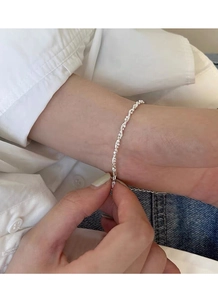 Delicato bracciale a catena in argento sterling S925 al polso con sfondo casual pulito