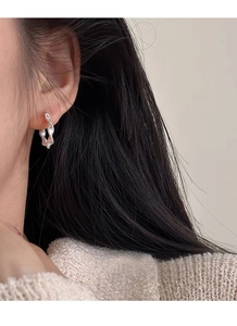 Close-up of elegant S925 sterling silver twisted hoop earrings worn by a model