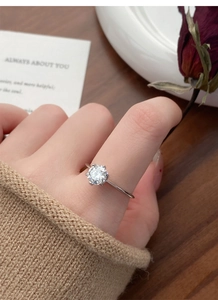 Detailed view of 1-carat moissanite ring with six-prong setting on silver band