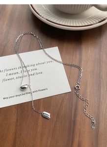 Detail shot of S925 sterling silver bean and Lucky square plate on a dainty chain