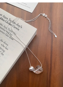 Detail of S925 sterling silver ball and irregular crystal pendant on an elegant chain