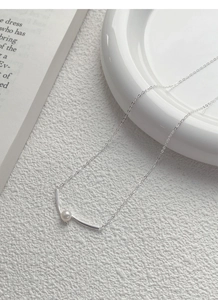 Elegant S925 silver necklace with minimalist pearl and curved bar pendant on white texture
