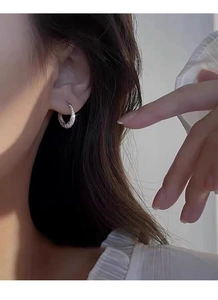 Close-up of S925 sterling silver hoop earrings with pave cubic zirconia on female ear